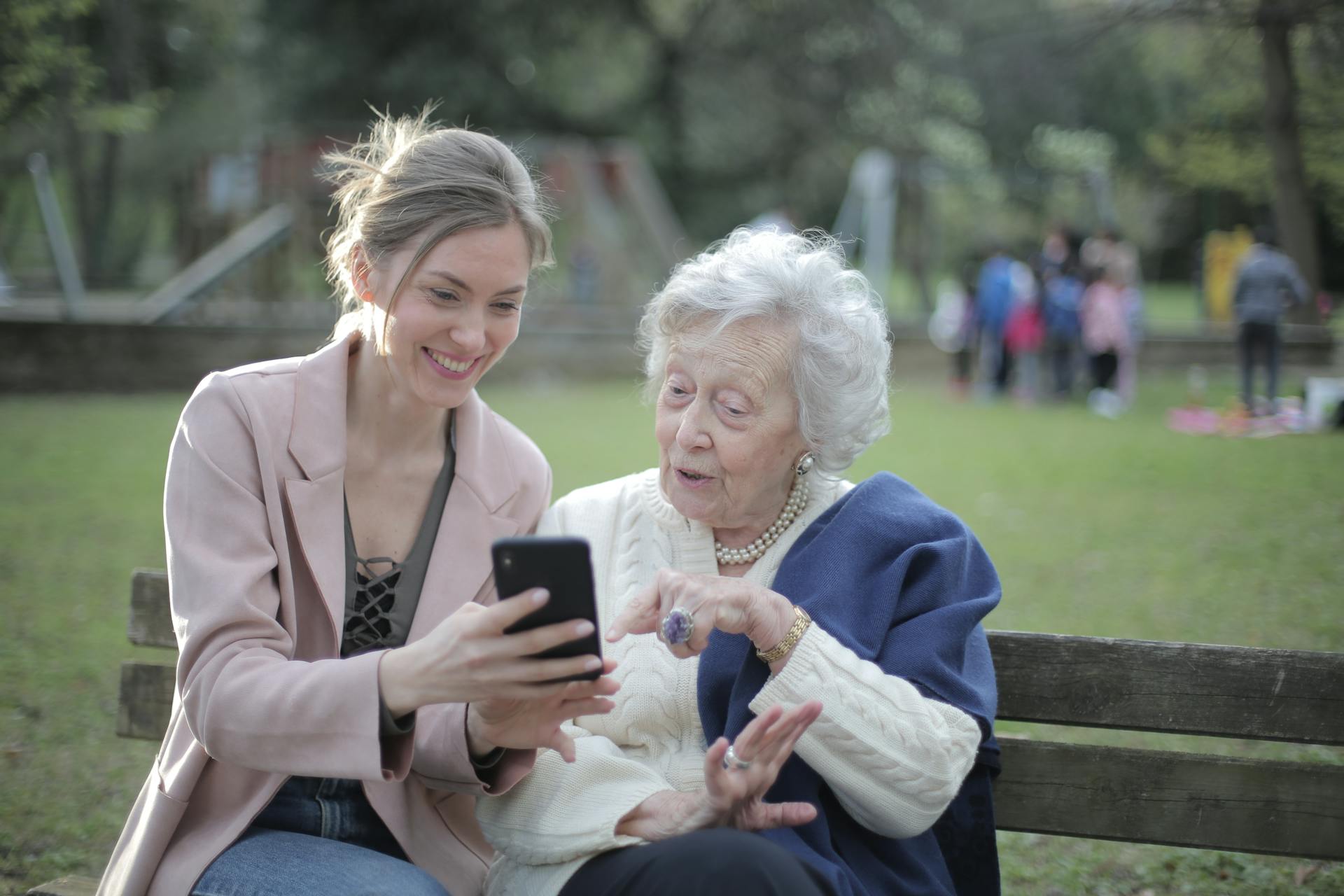 A woman helping a senior lady on her phone