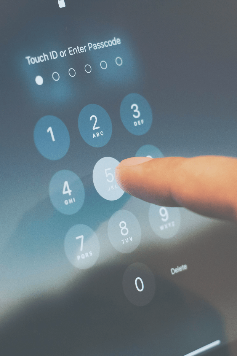A locked screen of a phone or tablet, with a hand entering the strong  password.
